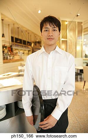 Portrait of a waiter standing and holding a tray View Large Photo Image Stock Photograph - Portrait of a waiter standing and holding a tray. Fotosearch