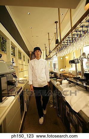 Stock Image - Portrait of a waiter standing in the kitchen. Fotosearch