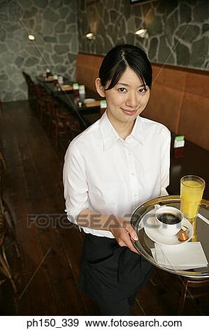 Stock Photo - Portrait of a waitress holding a serving tray. Fotosearch
