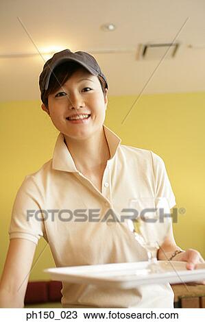 Portrait of a waitress holding a tray and smiling View Large Photo Image Stock Image - Portrait of a waitress holding a tray and smiling. Fotosearch