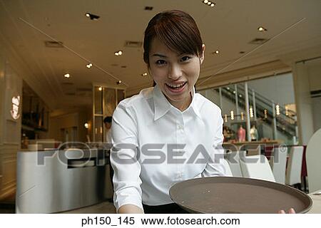 Portrait of a waitress holding a tray and smiling View Large Photo Image Stock Photography - Portrait of a waitress holding a tray and smiling. Fotosearch