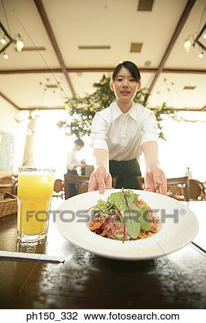 Portrait of a waitress serving food on the table View Large Photo Image Stock Image - Portrait of a waitress serving food on the table. Fotosearch