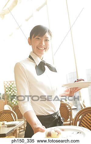 Portrait of a waitress serving food on the table View Large Photo Image Stock Photography - Portrait of a waitress serving food on the table. Fotosearch