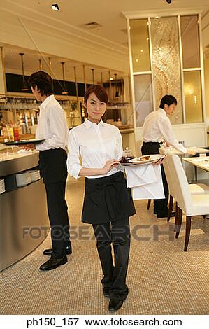 Portrait of a waitress standing in the kitchen with two waiters in the background View Large Photo Image Stock Photo - Portrait of a waitress standing in the kitchen with two waiters in the background. Fotosearch