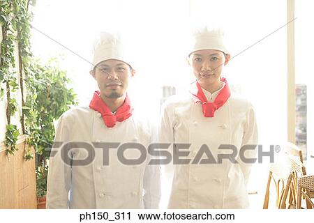 Portrait of two chefs standing in a restaurant View Large Photo Image Stock Image - Portrait of two chefs standing in a restaurant. Fotosearch