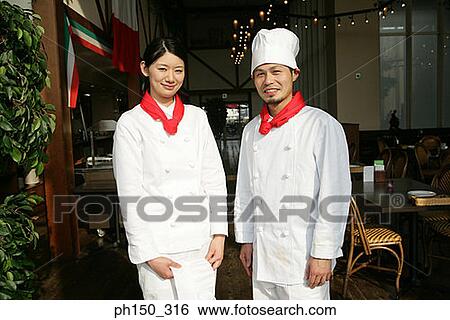 Portrait of two chefs standing in a restaurant and smiling View Large Photo Image Stock Photograph - Portrait of two chefs standing in a restaurant and smiling. Fotosearch