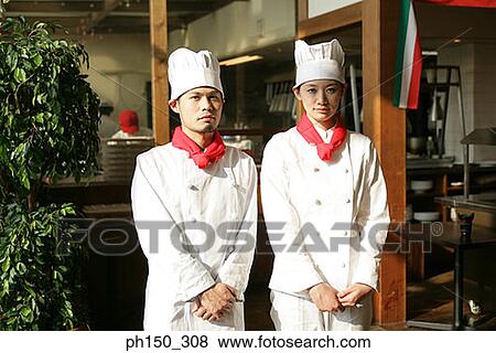 Stock Photo - Portrait of two chefs standing in front of a restaurant. Fotosearch