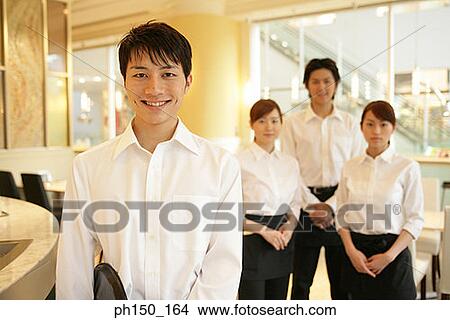 Portrait of two waiters and two waitresses standing in a restaurant View Large Photo Image Picture - Portrait of two waiters and two waitresses standing in a restaurant. Fotosearch