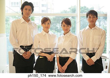 Picture - Portrait of two waiters and two waitresses standing in a restaurant. Fotosearch