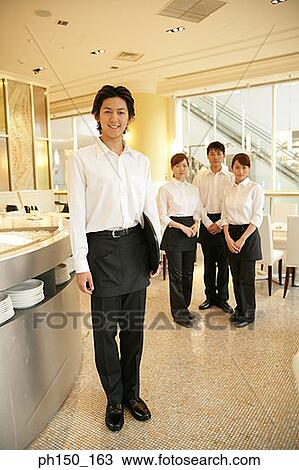 Portrait of two waiters and two waitresses standing in a restaurant View Large Photo Image Stock Image - Portrait of two waiters and two waitresses standing in a restaurant. Fotosearch