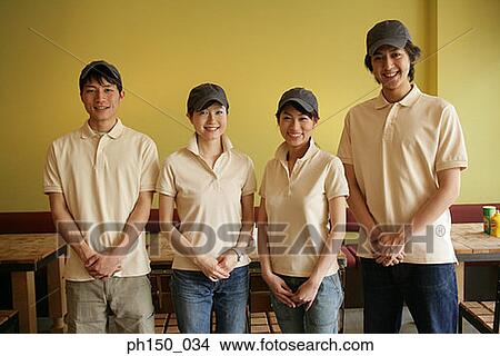 Picture - Portrait of two waiters with two waitresses smiling. Fotosearch
