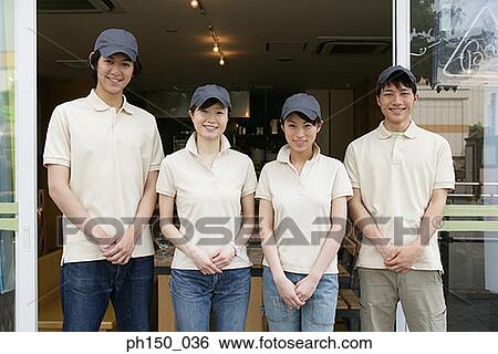 Stock Photograph - Portrait of two waiters with two waitresses standing in front of a restaurant. Fotosearch