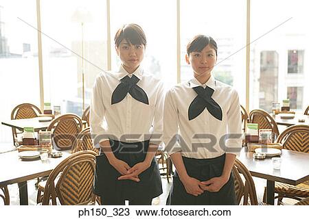 Stock Image - Portrait of two waitresses standing in a restaurant. Fotosearch