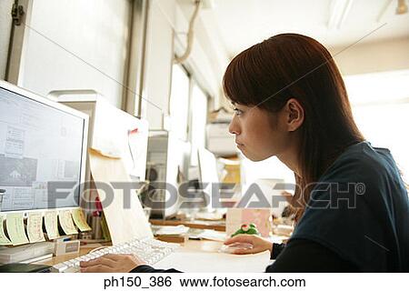 Side profile of a businesswoman working on a computer View Large Photo Image Stock Photograph - Side profile of a businesswoman working on a computer. Fotosearch