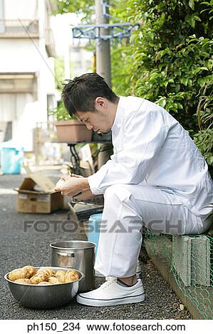 Side profile of a chef peeling raw potatoes View Large Photo Image Picture - Side profile of a chef peeling raw potatoes. Fotosearch
