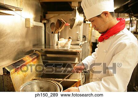 Stock Photo - Side profile of a chef preparing food in the kitchen. Fotosearch