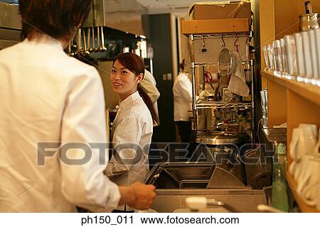 Side profile of a female chef looking at a male chef and smiling View Large Photo Image Stock Image - Side profile of a female chef looking at a male chef and smiling. Fotosearch