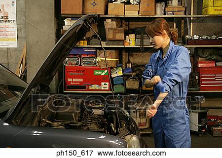 Side profile of a female mechanic standing in front of a car View Large Photo Image Stock Photo - Side profile of a female mechanic standing in front of a car. Fotosearch