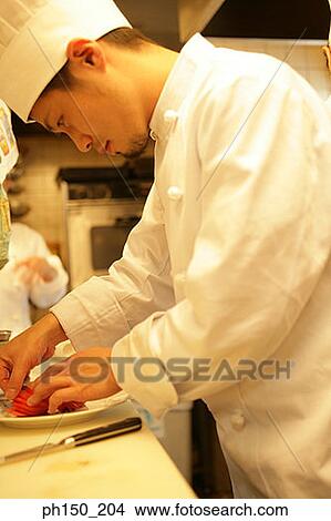 Side profile of a male chef arranging tomato slices in a plate View Large Photo Image Picture - Side profile of a male chef arranging tomato slices in a plate. Fotosearch