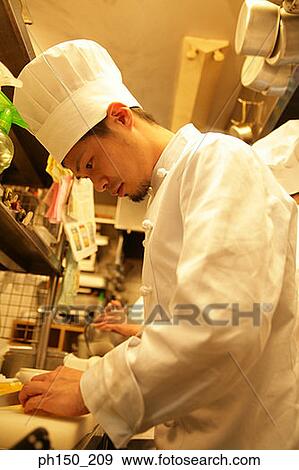 Stock Photo - Side profile of a male chef working in the kitchen. Fotosearch