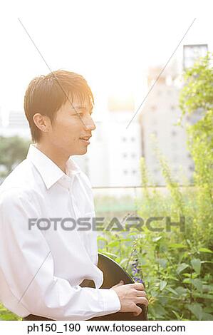 Stock Image - Side profile of a waiter holding a serving tray. Fotosearch