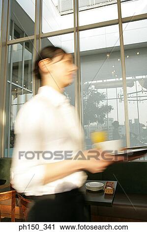 Stock Image - Side profile of a waitress holding a serving tray. Fotosearch