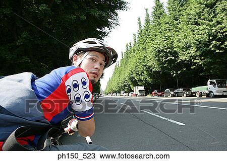 Side profile of a young man riding a bicycle View Large Photo Image Stock Image - Side profile of a young man riding a bicycle. Fotosearch