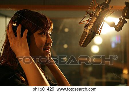 Side profile of a young woman recording music in recording studio View Large Photo Image Stock Photo - Side profile of a young woman recording music in recording studio. Fotosearch