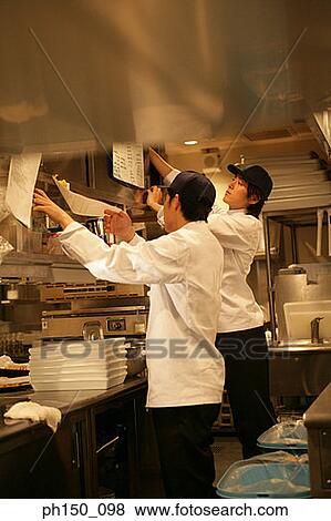 Side profile of two waiters standing in the kitchen View Large Photo Image Stock Photo - Side profile of two waiters standing in the kitchen. Fotosearch