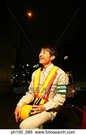 Stock Photography - Traffic cop holding a hardhat and a nightstick. Fotosearch