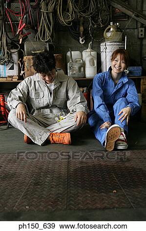 Two auto mechanics sitting in an auto repair shop and smiling View Large Photo Image Stock Photo - Two auto mechanics sitting in an auto repair shop and smiling. Fotosearch