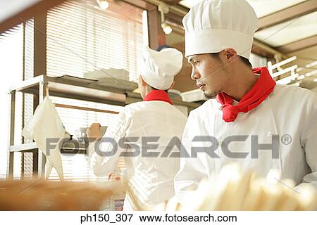 Two chefs preparing food in the kitchen View Large Photo Image Stock Photo - Two chefs preparing food in the kitchen. Fotosearch