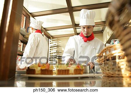 Two chefs preparing food in the kitchen View Large Photo Image Stock Photograph - Two chefs preparing food in the kitchen. Fotosearch