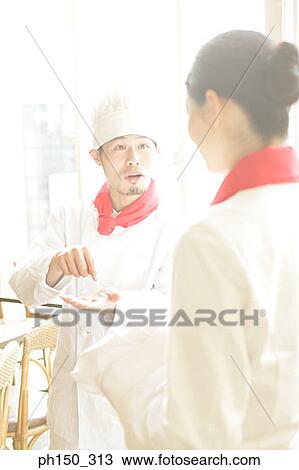 Two chefs standing in a restaurant and discussing View Large Photo Image Stock Image - Two chefs standing in a restaurant and discussing. Fotosearch