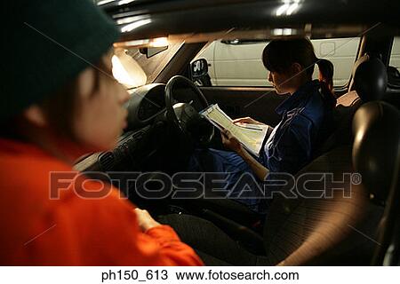 Stock Image - Two female auto mechanics in an auto repair shop. Fotosearch