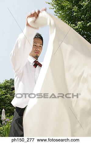 Waiter holding a tablecloth View Large Photo Image Stock Photo - Waiter holding a tablecloth. Fotosearch