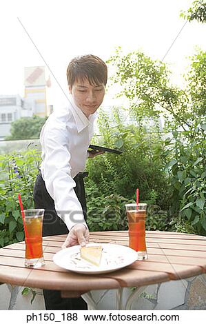 Waiter picking up a plate from the table View Large Photo Image Stock Photo - Waiter picking up a plate from the table. Fotosearch