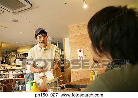 Waiter taking an order from a customer and smiling View Large Photo Image Stock Photo - Waiter taking an order from a customer and smiling. Fotosearch