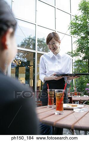 Picture - Waitress holding a serving tray and smiling. Fotosearch