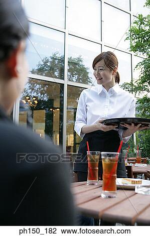Stock Image - Waitress holding a serving tray and smiling. Fotosearch