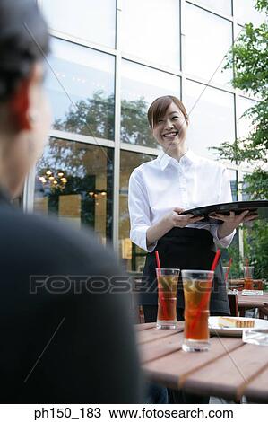 Waitress holding a serving tray and smiling View Large Photo Image Stock Image - Waitress holding a serving tray and smiling. Fotosearch