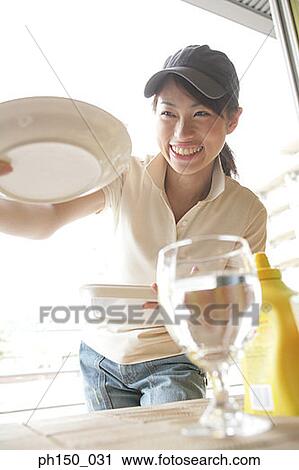 Waitress holding a tray and a plate View Large Photo Image Stock Image - Waitress holding a tray and a plate. Fotosearch