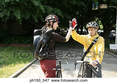 Young man and a young woman high-fiving View Large Photo Image Stock Photo - Young man and a young woman high-fiving. Fotosearch