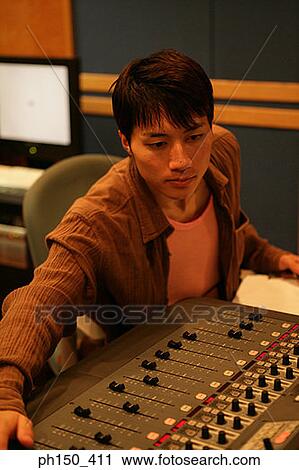 Young man operating a sound mixer View Large Photo Image Stock Image - Young man operating a sound mixer. Fotosearch