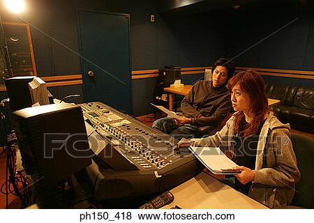 Young woman and a young man sitting in a recording studio View Large Photo Image Stock Photo - Young woman and a young man sitting in a recording studio. Fotosearch