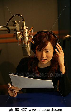 Stock Photo - Young woman recording music in a recording studio. Fotosearch