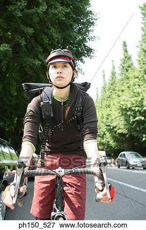 Young woman riding a bicycle View Large Photo Image Stock Photo - Young woman riding a bicycle. Fotosearch