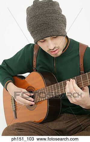Stock Image - Close-up of a young man playing the guitar. Fotosearch