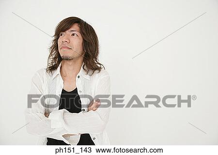 Close-up of a young man standing with his arms crossed View Large Photo Image Stock Image - Close-up of a young man standing with his arms crossed. Fotosearch