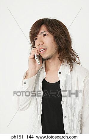 Close-up of a young man talking on a mobile phone View Large Photo Image Picture - Close-up of a young man talking on a mobile phone. Fotosearch